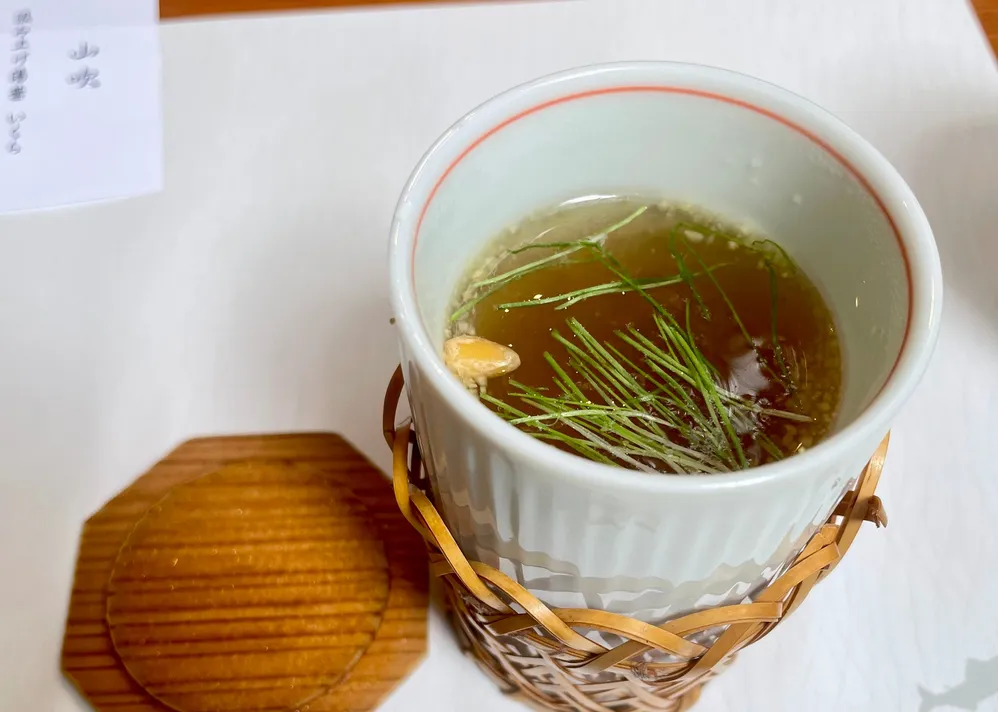 竹の網に包まれた碗の吸い物と木の蓋