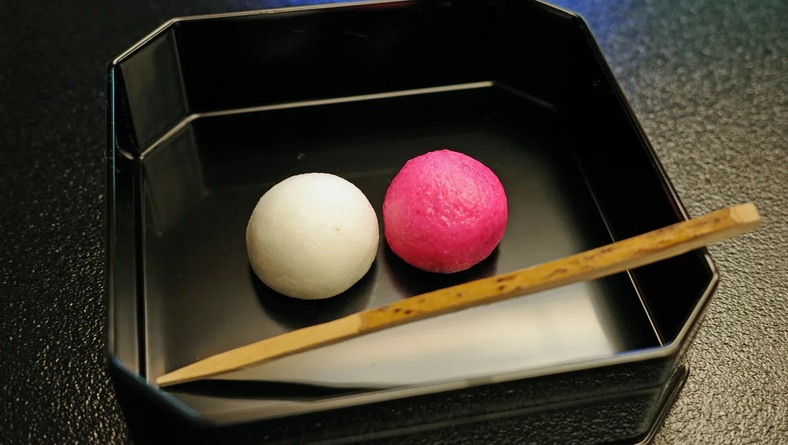 黒い器に入った紅白の和菓子