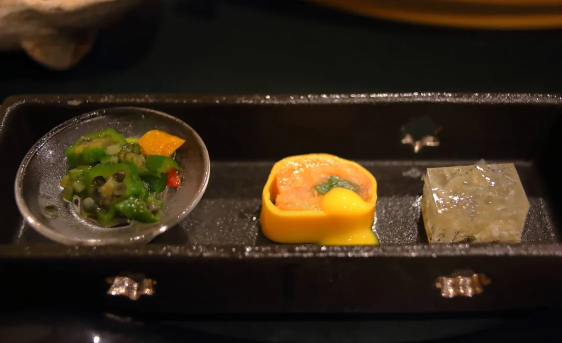 黒い器に盛られた三種の和食の前菜